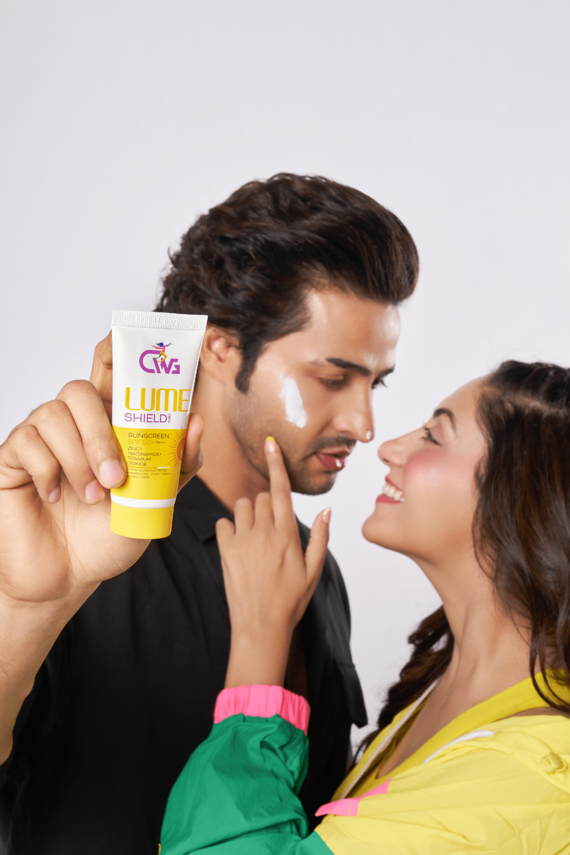 CWG lume shield trio sunscreen Test applied on a man's face, with a woman playfully pointing at him.
